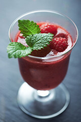 Fresh smoothie in a glass. Dark background. Close up.	