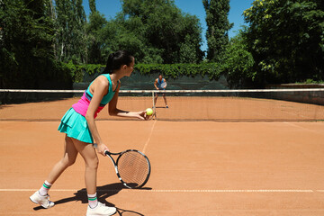Fototapeta na wymiar Couple playing tennis on court during sunny day