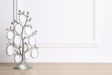 Blank metal family tree frame on wooden table. Space for text