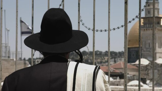 Jewish Orthodox man praying behind the walls of the dome of the rock. Jerusalem, Israel.