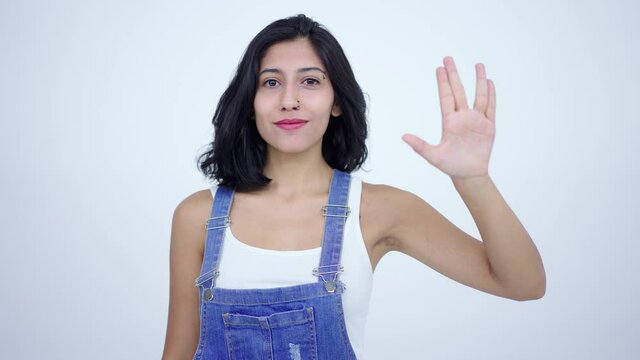 Saluting with spock hand gesture. Young female hand makes a vulcan greeting gesture. White background. The concept of gestures. Live long and prosper.