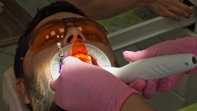 Latvia. Riga. 04.08.2019 Dentist In a Medical Gloves Works with a Patient Man in a Dental Office. Dentistry. Healthcare and Medicine Concept