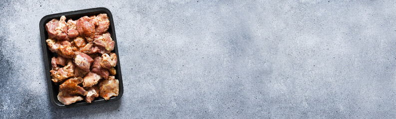 Marinated shish kebab with onion and lemon. Pork meat with spices on a tray.