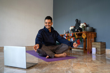 latin man does yoga postures and virtual meditation at home