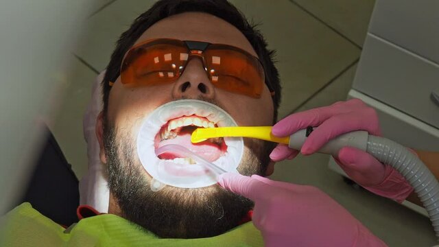 Latvia. Riga. 04.08.2019 Dentist In a Medical Gloves Works with a Patient Man in a Dental Office. Dentistry. Healthcare and Medicine Concept