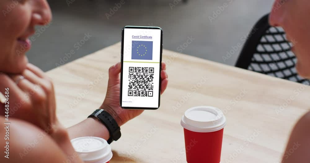 Aufkleber man at cafe showing smartphone with covid vaccination certificate, eu flag and qr code on screen