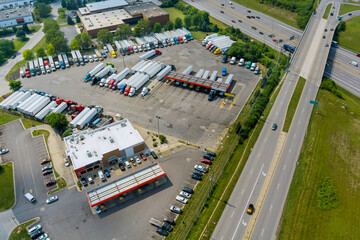 Resting place the truck stop on various types of trucks in a parking lot off the highway with gas...