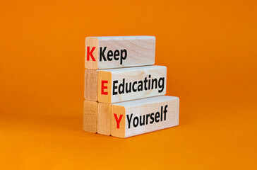 KEY, keep educating yourself symbol. Wooden blocks with words 'KEY, keep educating yourself'. Beautiful orange background, copy space. Business, educational and KEY, keep educating yourself concept.