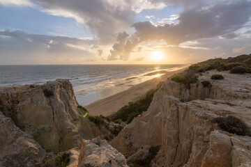 Fototapeta premium unas vistas de la bella playa de Mazagon, situada en la provincia de Huelva, España. Con sus acantilados , pinos, dunas , vegetacion verde y un cielo con nubes. Atardeceres preciosos