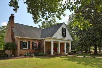 Brick country family home with lush lawn and trees