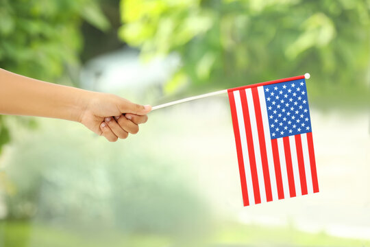 African-American child holding national flag on blurred background, closeup