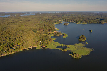 Forest-covered islands in the sea Summer, sunny day. Scandinavian nature, Finland. Photo from the drone.