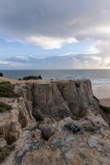 Fototapeta na wymiar unas vistas de la bella playa de Mazagon, situada en la provincia de Huelva, España. Con sus acantilados , pinos, dunas , vegetacion verde y un cielo con nubes. Atardeceres preciosos