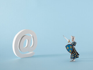 white word at for email and internet messages and warrior toy on the pastel blue background....