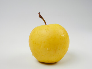 Fresh yellow apple with water drops, isolated on a white background