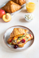 Croissant sandwich with cream cheese, nectarine and cherry and fresh ingredient for making tasty breakfast.