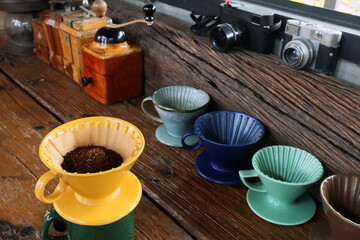 Set of manual vivid color dripper pour over coffee maker preparation on the table.background film camera. Selective focus foreground with copy space.