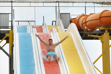 Handsome man on slide in water park