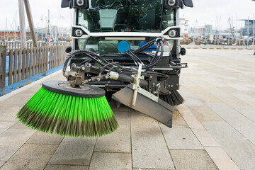 Close up of green brush of new generation automatic electric street sweeper that cleans the streets