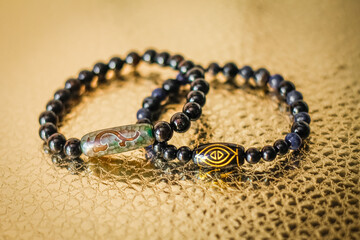 on the golden surface is a bracelets made of natural stone beads