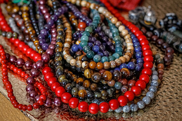a variety of beads made of natural stones are randomly scattered on the golden surface next to...