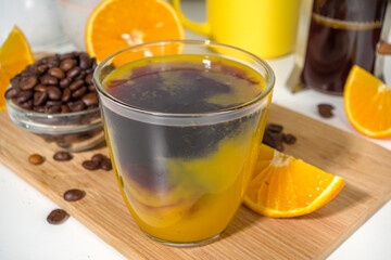 Bumble bee Coffee cocktail. Homemade hot drink with espresso and orange juice, on white kitchen table copy space