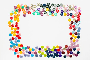 frame of multicolored buttons for clothes on a white background