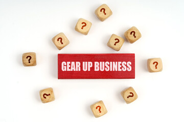On the table are cubes with questions and a red plaque with the inscription - Gear Up Business