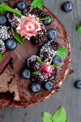 
Fresh delicious homemade chocolate cake with berries on a black table, top view