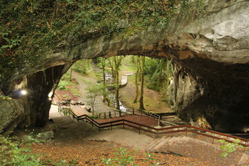 Zugarramurdi caves with lots of vegetation and a river in the background