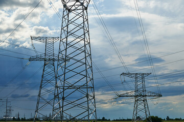 High-voltage electric lines, towers and industrial infrastructure against the blue sky