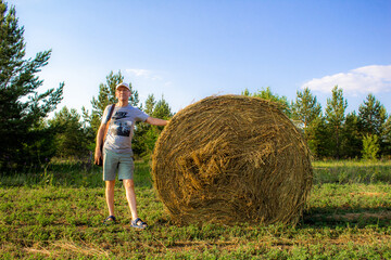 Naklejka na ściany i meble a person standing next to hay bale