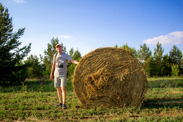 Naklejka na ściany i meble a person standing next to hay bale with copy space