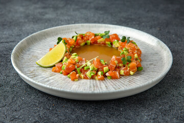Salmon and avocado tartare. Citrus sauce. Ready menu for the restaurant. Neutral gray blue textured background