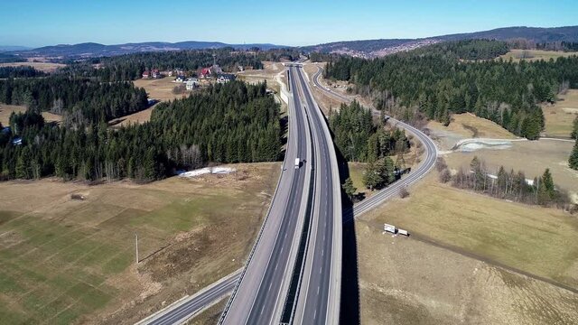 Old road and new highway from Krakow to Zakopane in Poland, called Zakopianka with viaducts, elevated crossroads and cars. Aerial 4K video in winter