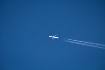 Ein Passagierjet, Flugzeug hinterlässt am Himmel weiße Kondensstreifen.
