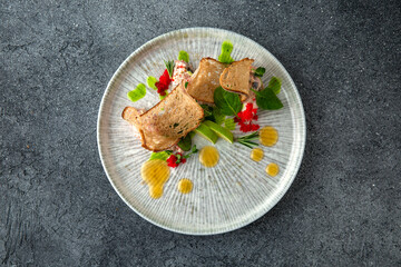 Crab meat pate with caviar, bread chips and citrus. Ready menu for the restaurant. Neutral gray blue textured background