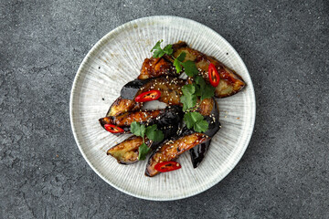 Spicy baked eggplant. Ready menu for the restaurant. Neutral gray blue textured background