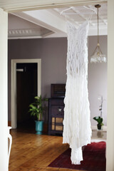 The beautiful and slim wedding dress in the room of the bride.