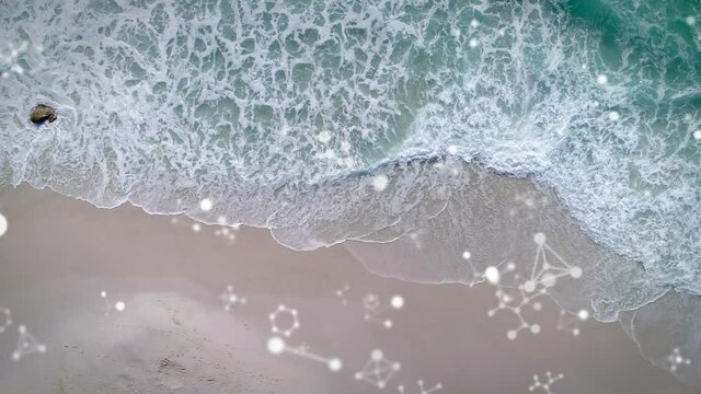 Digital composition of molecular structures floating against aerial view of the beach