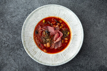 First course. Mexican soup with beans and prosciutto. Ready menu for the restaurant. Neutral gray blue textured background