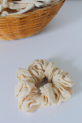 Flat lay - Scrunchie and bag made of organic cotton fabric, and straw basket.