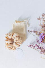 Obraz na płótnie Canvas Flat lay - Scrunchie and bag made of organic cotton fabric, and wild flowers.