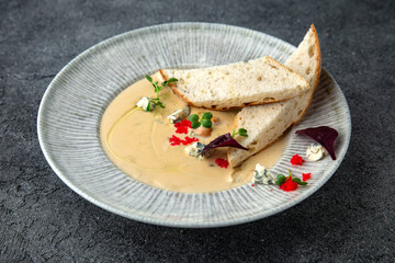First course, seafood cream soup with salmon caviar, squid and caviar. Ready menu for the restaurant. Neutral gray blue textured background