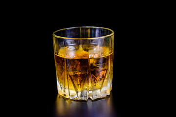 Glass of whiskey isolated on the black background