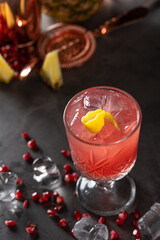 refreshing and light pomegranate and pineapple summer cocktail with ice cubes