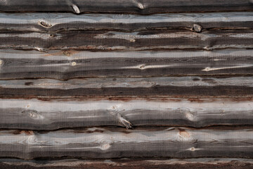 Wooden background. Old fence after rain, close-up. Wall of uneven horizontally spaced boards.