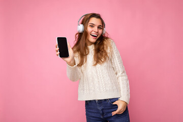 Beautiful happy smiling young woman wearing stylish casual outfit isolated on background wall...