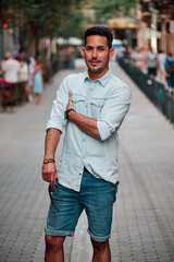 Portrait of a dark-haired Latin boy posing for a photo session on a street in the city of Barcelona..