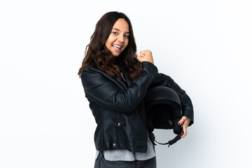 Young woman holding a motorcycle helmet over isolated white background celebrating a victory